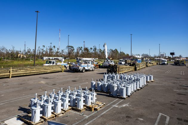 Pike Electric workers load power poles in Lynn Haven, Florida in preparation for assisting Gulf Power Company in recovery from Hurricane Michael